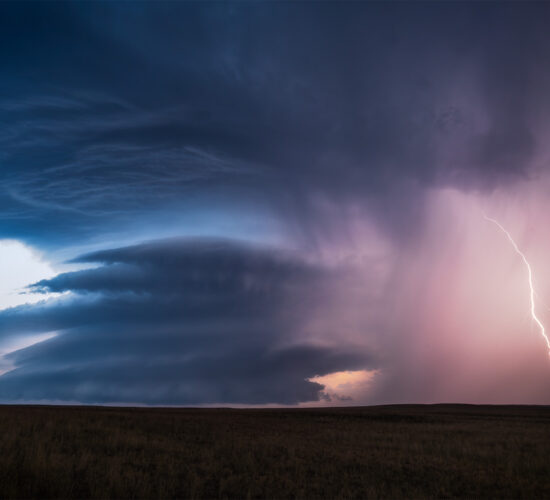 A photograph of a supercell thunderstorm on the Canadian prairie with lightning in the hail core