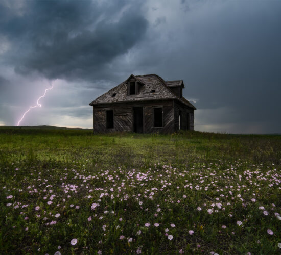 A storm photograph of an abandoned house in south Saskatchewan with lightning behind