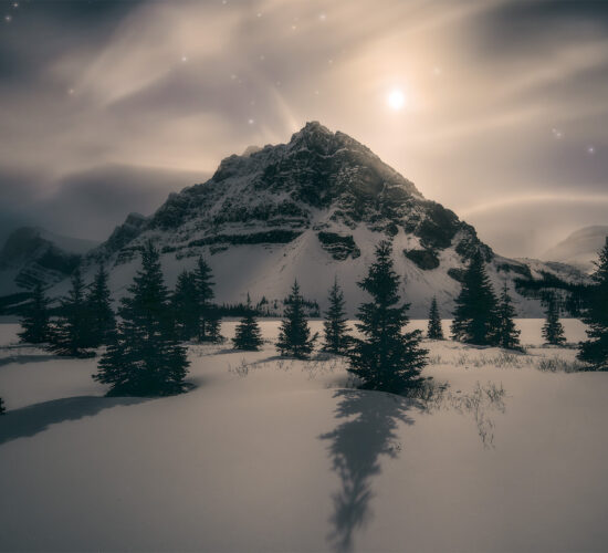 A winter photograph in the Canadian Rockies of the moon on Bow Lake in Banff National Park