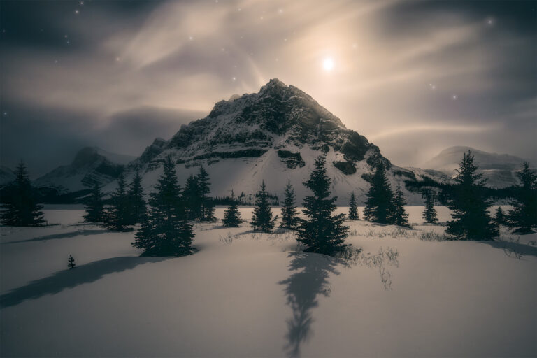 A winter photograph in the Canadian Rockies of the moon on Bow Lake in Banff National Park