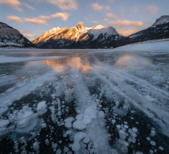 A winter landscape photograph of the Canadian Rockies at Spray Lakes with beautiful morning light on the mountains